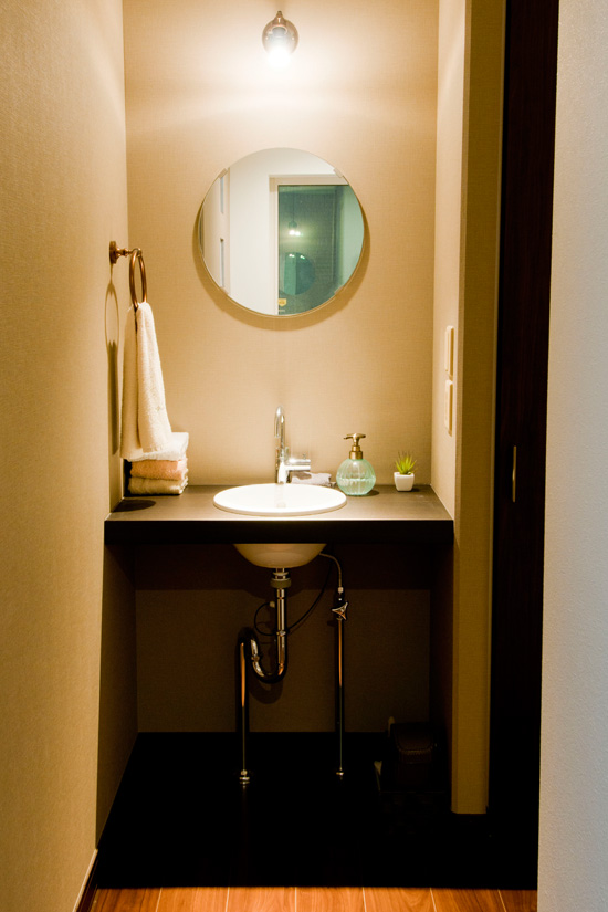 丸い鏡のかかった洗面スペース