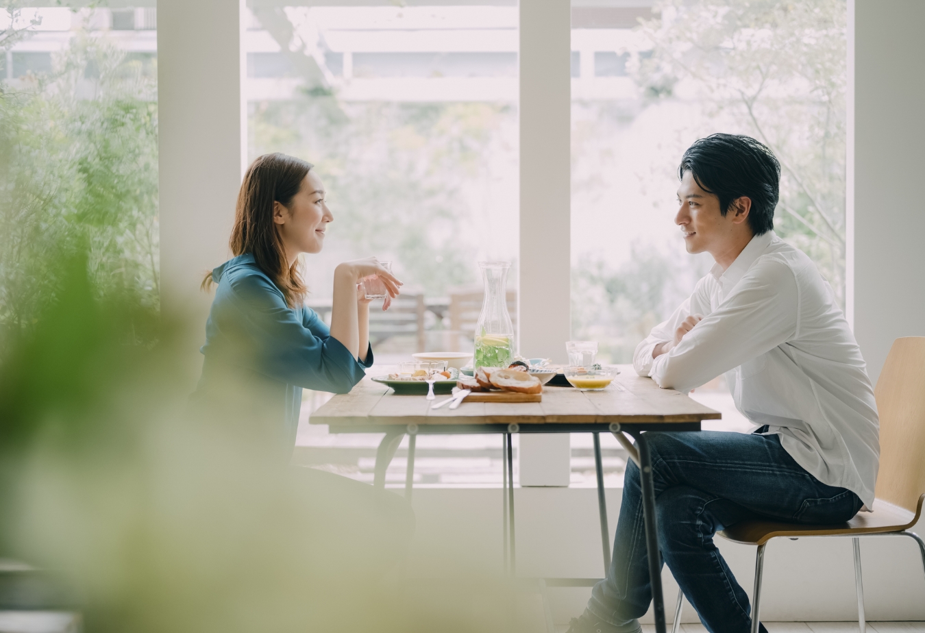食卓を挟んで話をしている新婚夫婦
