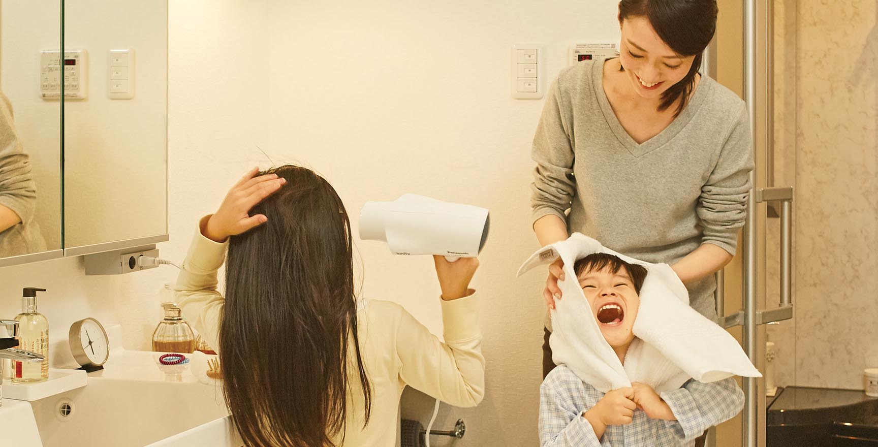 お風呂から上がって髪を乾かす子ども