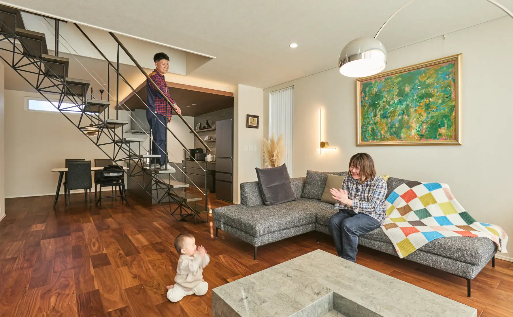 吹き抜け階段とカラフルなインテリアが特徴的なリビング