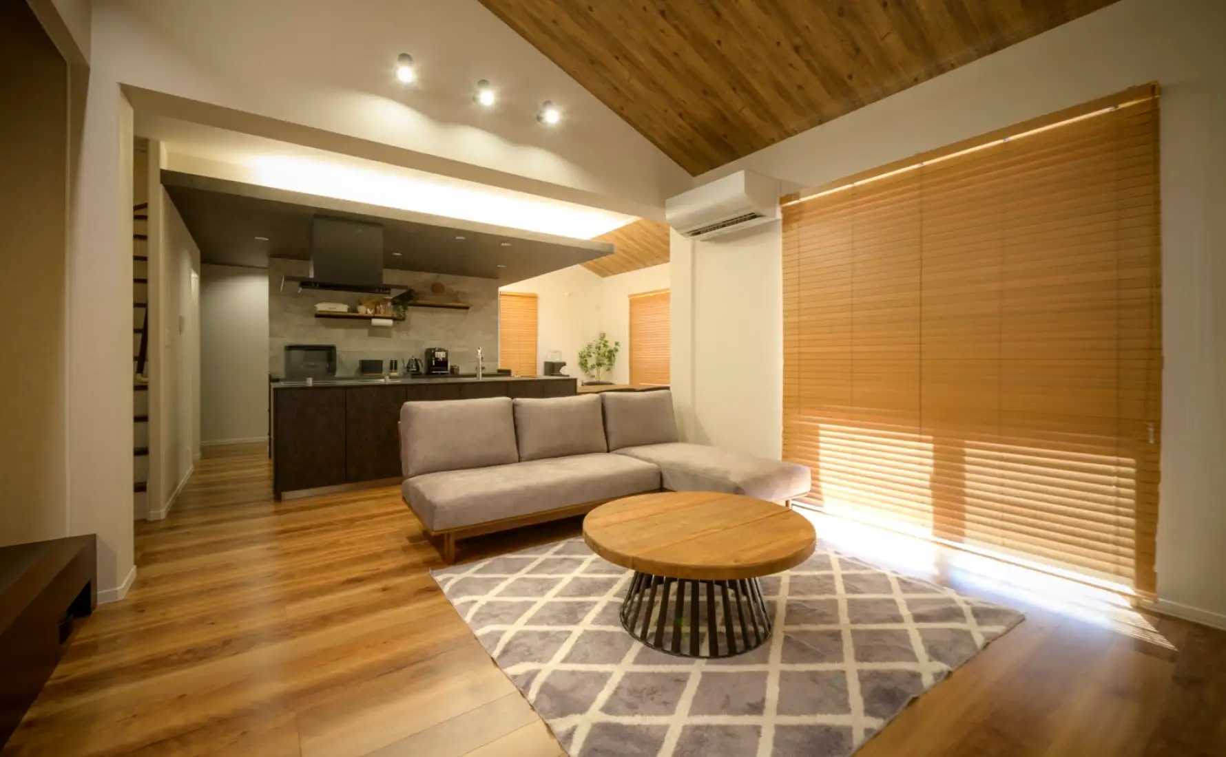 傾斜天井が開放的なリビングと奥にあるモダンなキッチン