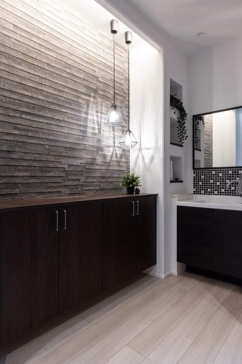 シューズボックス横に洗面台がありグレーのエコカラットが使われた玄関