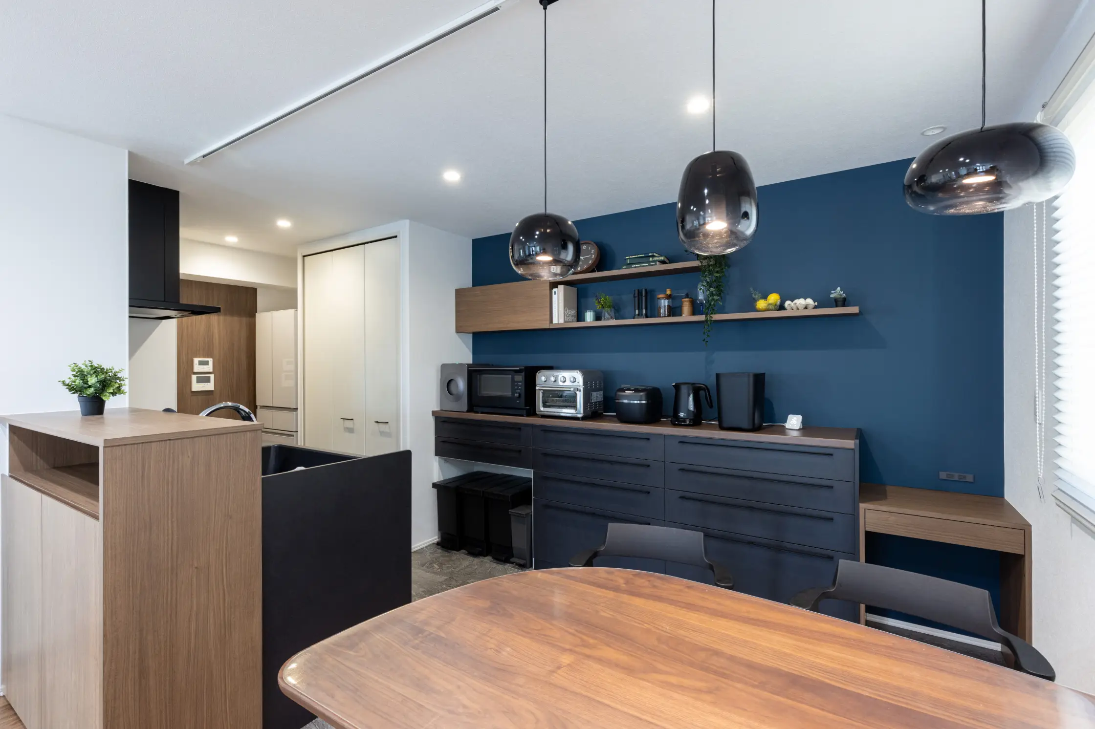 ダイニングのペンダントライトとダークトーンのキッチン