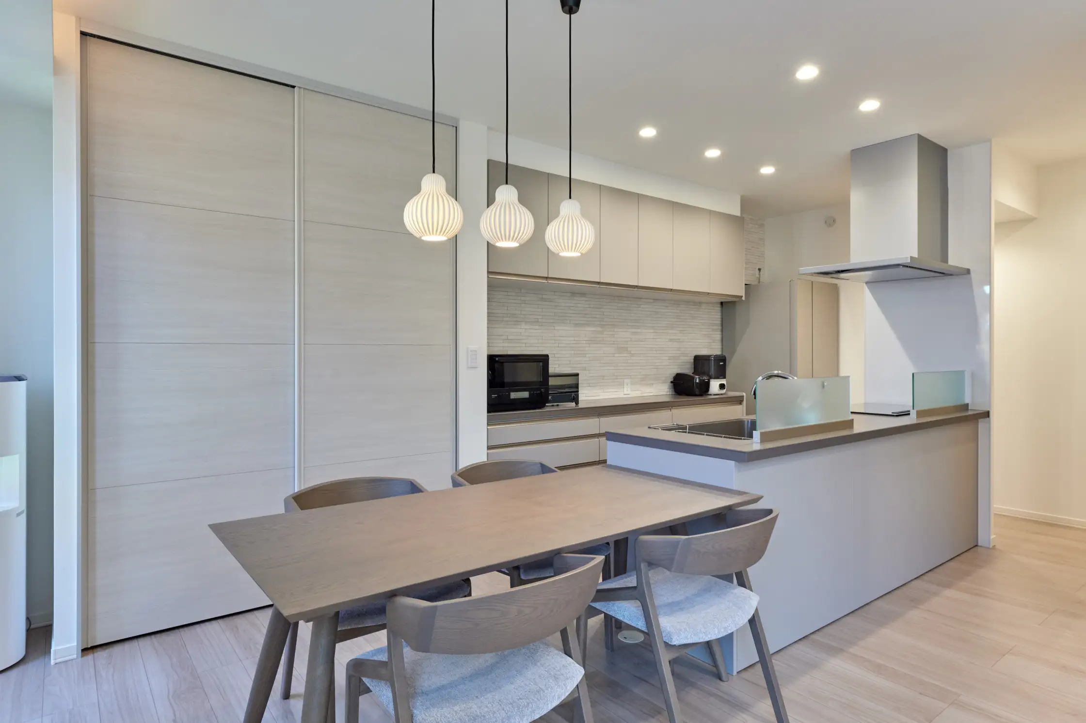 ペンダントライトがおしゃれな統一感のあるデザインのダイニングキッチン