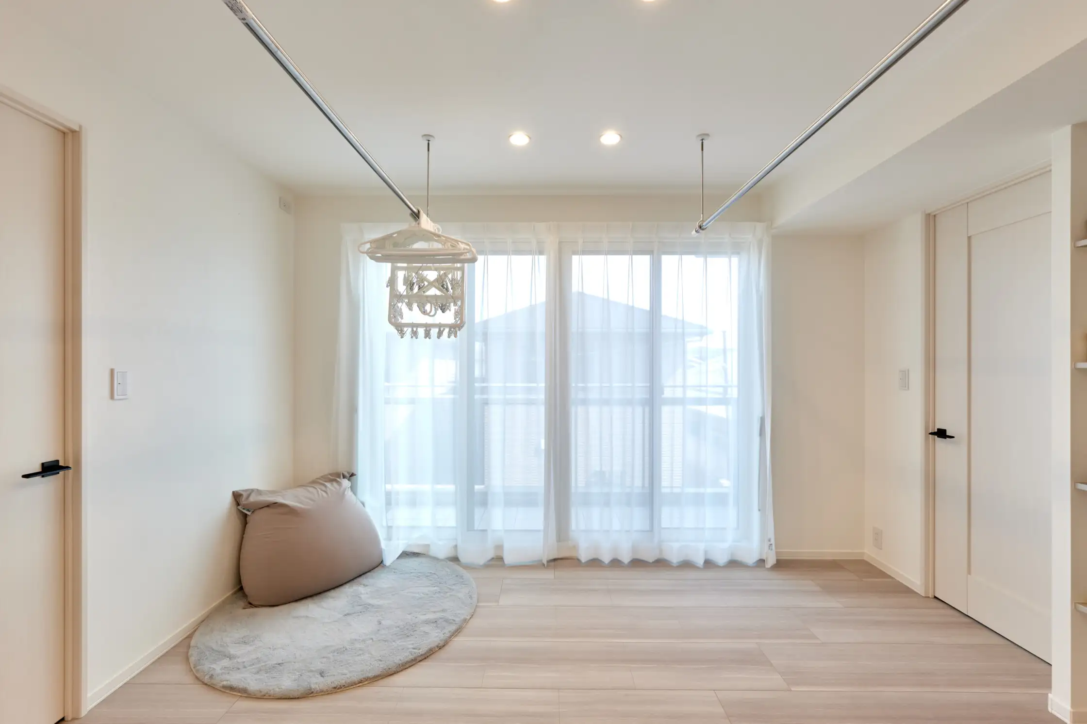 天井吊り下げ型の物干しが2つある窓付きの明るいホール