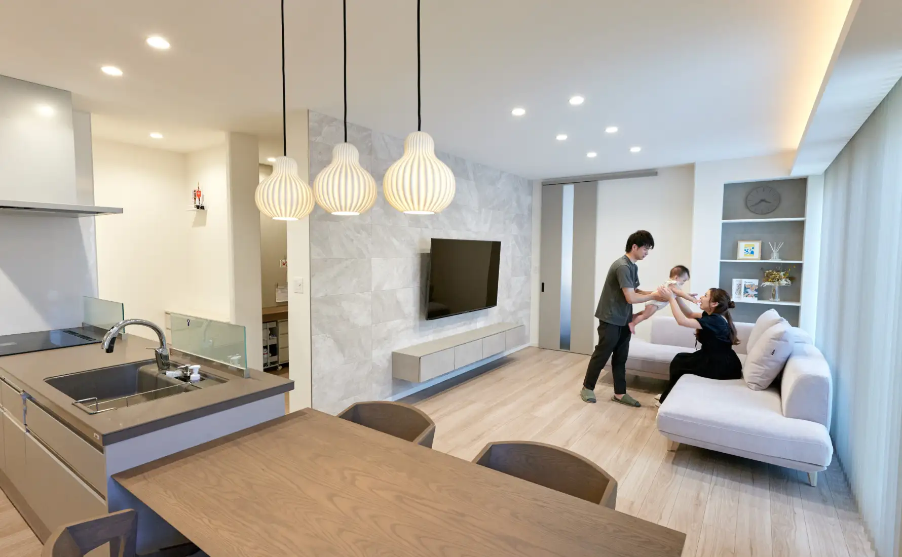 リビングのソファでご夫婦がお子様を抱いている様子