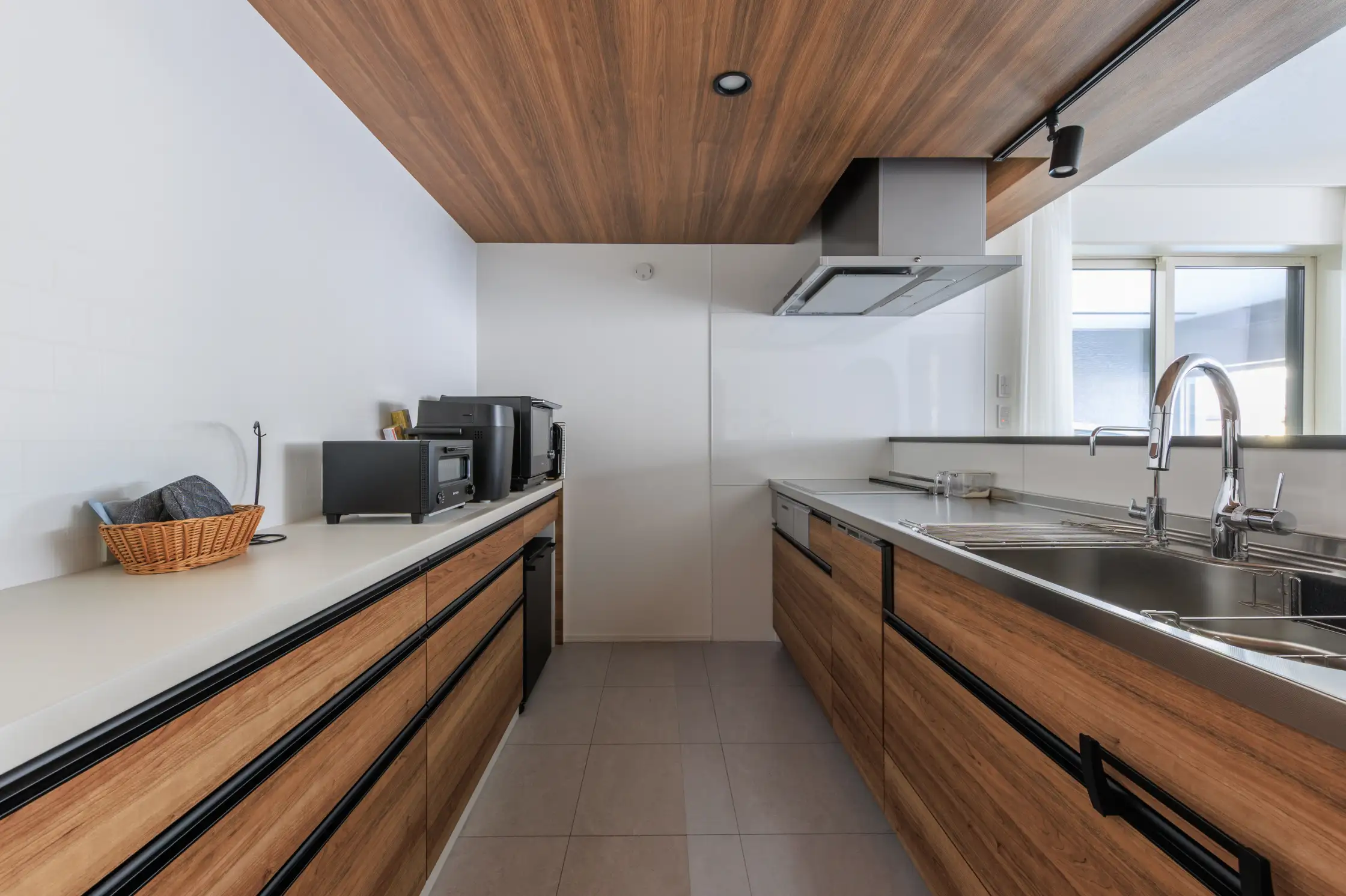 木調内装で整えアクセントに床タイルを施したキッチンスペース