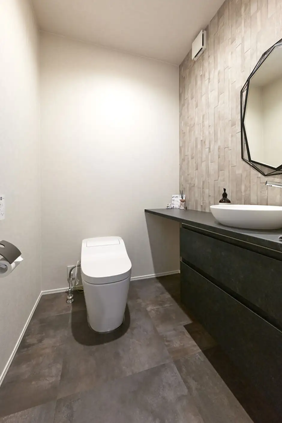 大きな手洗いカウンターのある、シックで上質な雰囲気のトイレ空間