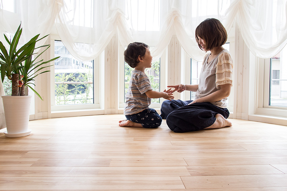 ボウウインドウの前で手遊びをする妻と子ども