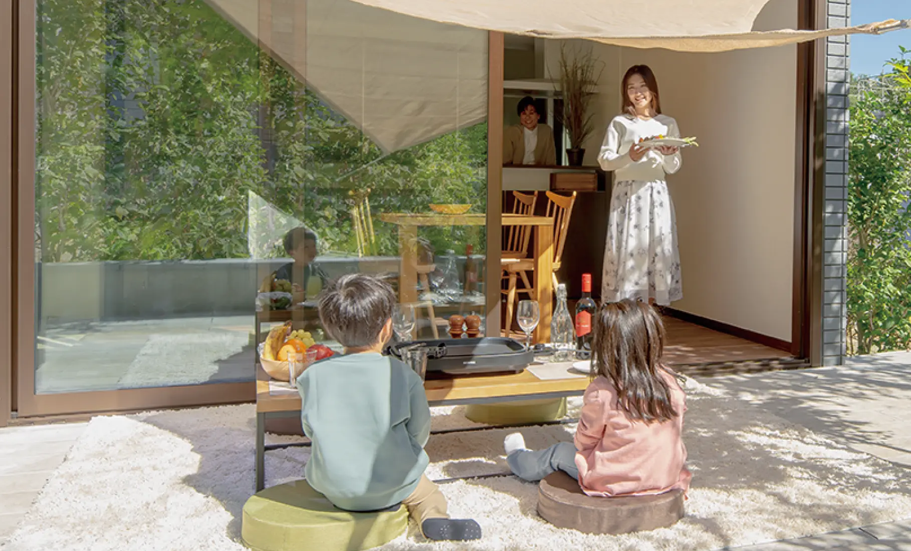 テラスでバーベキューを準備する家族