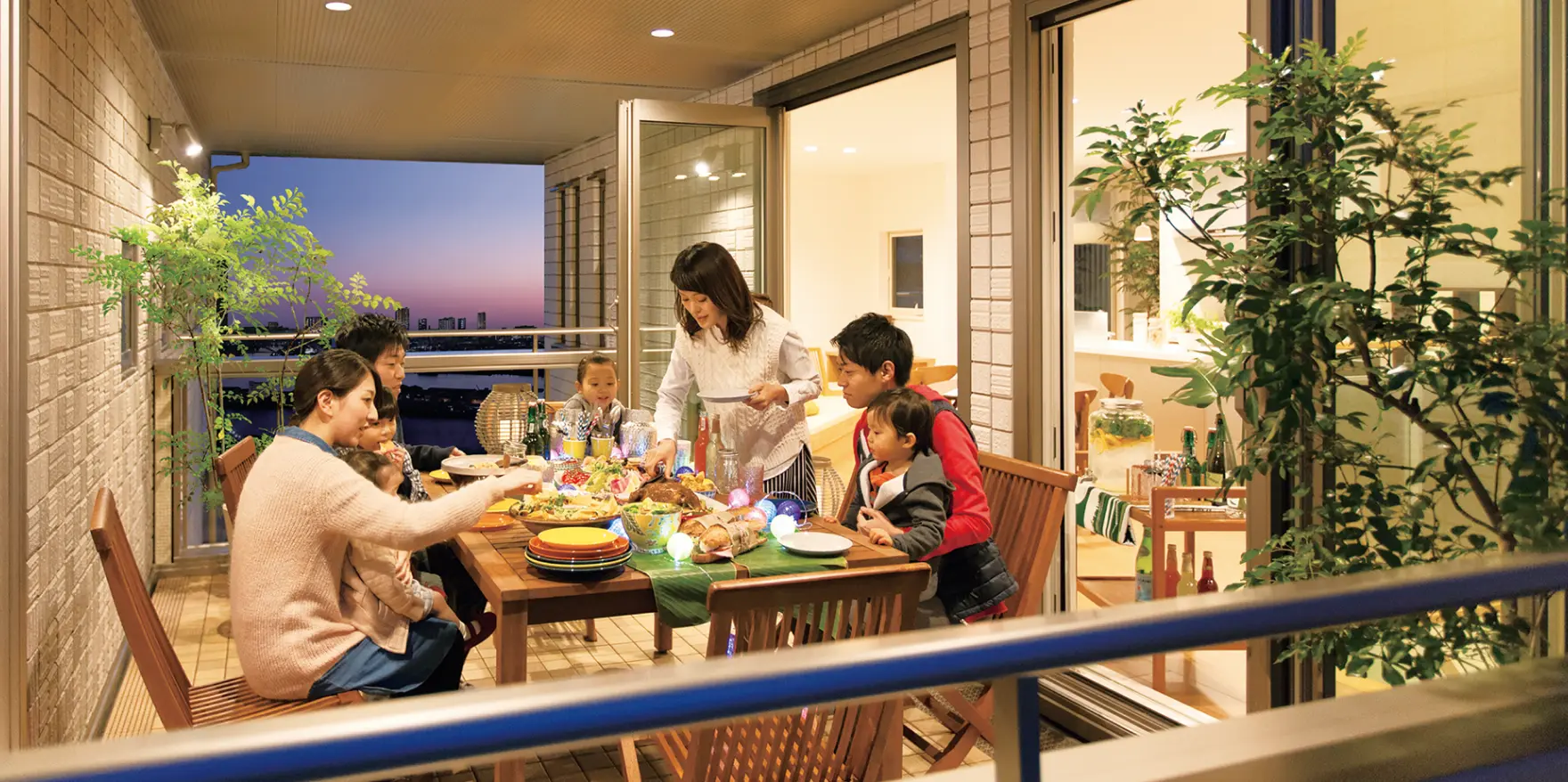 屋根付きのバルコニーでパーティーを楽しむ家族とその友人