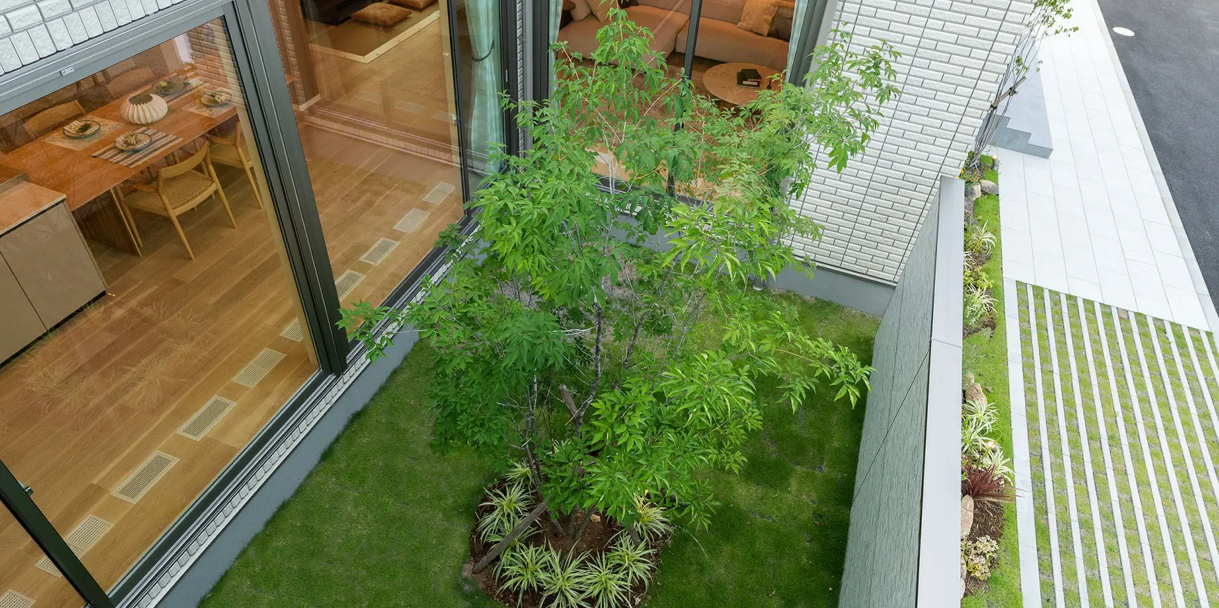 塀で視線を遮りつつ、室内からの景観を豊かにする植栽のある中庭