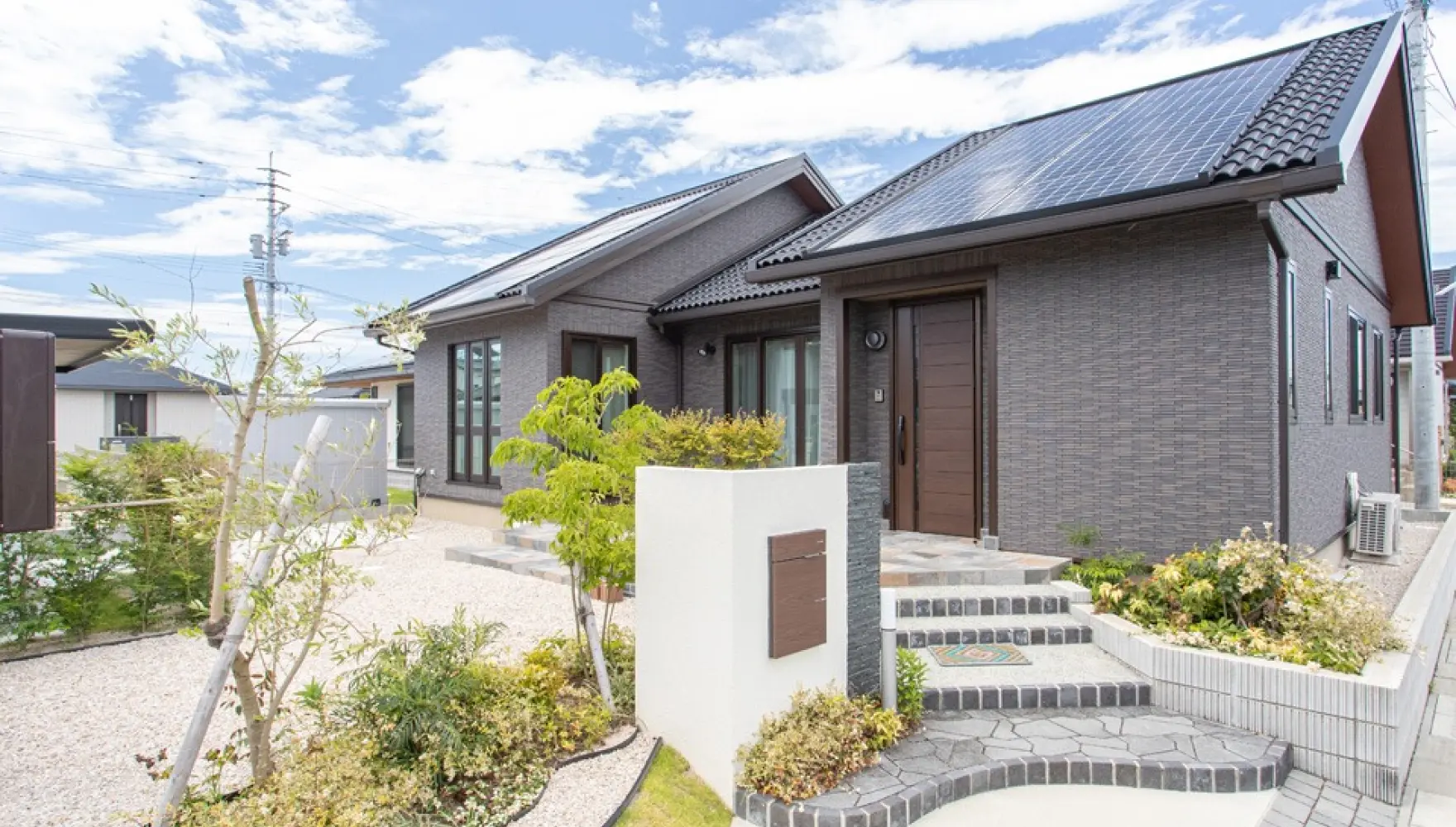 ゆるやかに玄関へアプローチする乱形石の階段が印象的なオープン外構