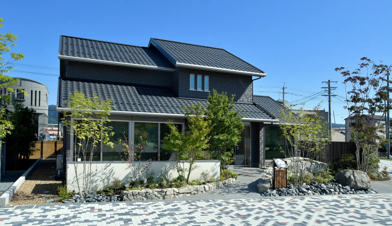 瓦屋根の住まいに調和する、植栽と石積みで整えた和モダンの外構