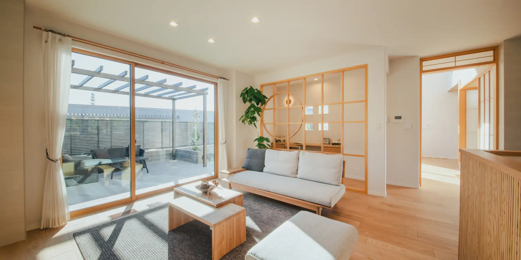 パーゴラ付きのテラスからフラットにつながる和モダンテイストのリビング
