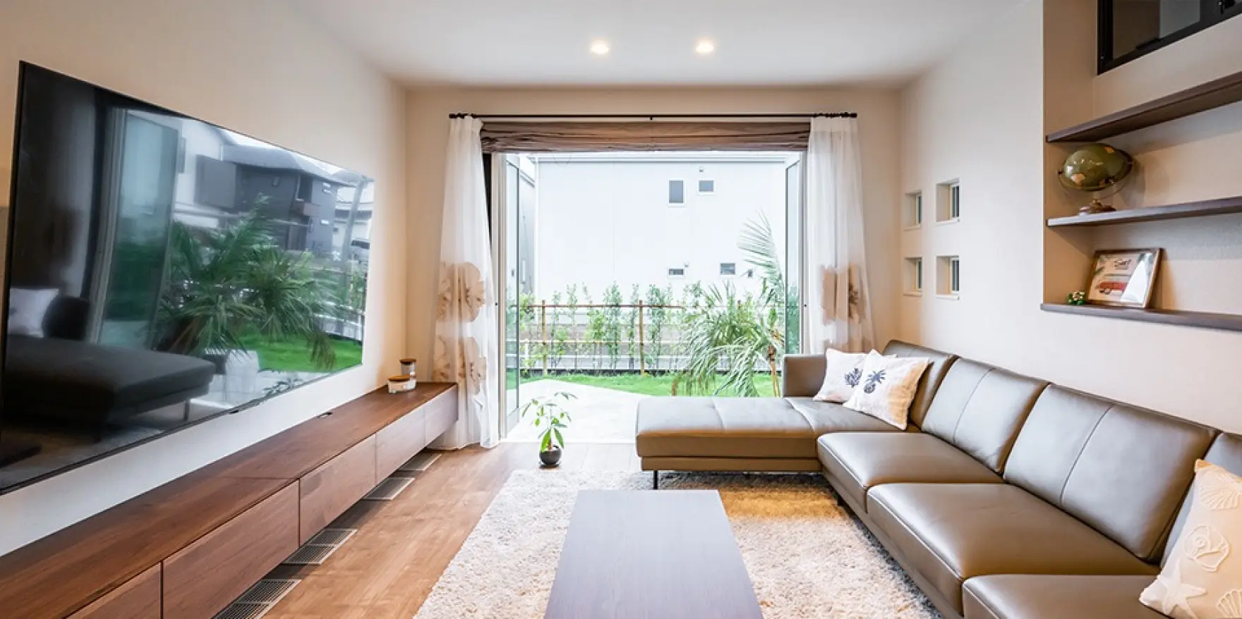 フルオープンの窓を通じて、テラスから庭までひと続きに感じられるリビング