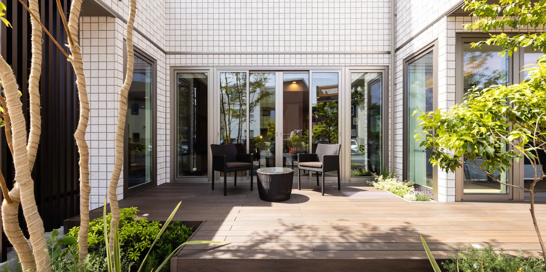 建物に囲まれた、プライベート感のあるウッドデッキのテラス