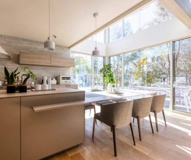 大きな吹き抜けと窓があるダイニング