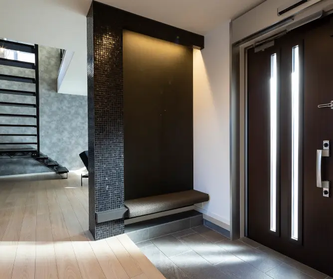 壁の厚みを生かしたコンパクトなベンチがある玄関