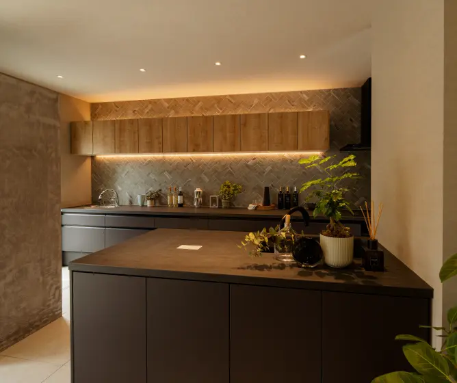 木の吊戸棚と壁面タイルのあるキッチン