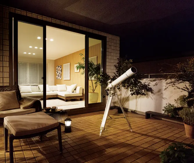 望遠鏡とソファを置いた屋上バルコニー