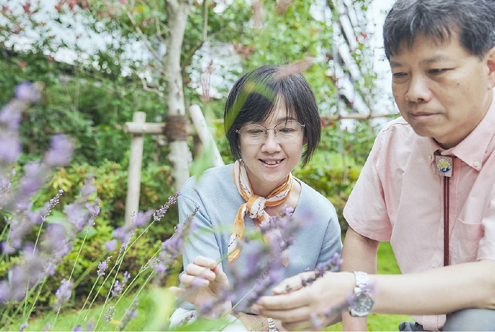 咲き誇る植栽につい笑顔になるご夫婦（エントランス）