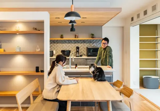 ダイニングで夫婦が猫と過ごしている様子