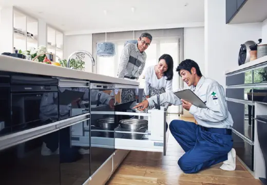 室内で夫婦が設備点検を受けている様子